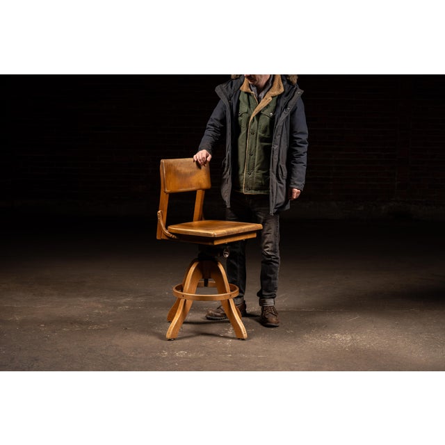Solid wood drafting stool featuring a shaped plank seat and curved backrest mounted to an early iron swivel and height-...