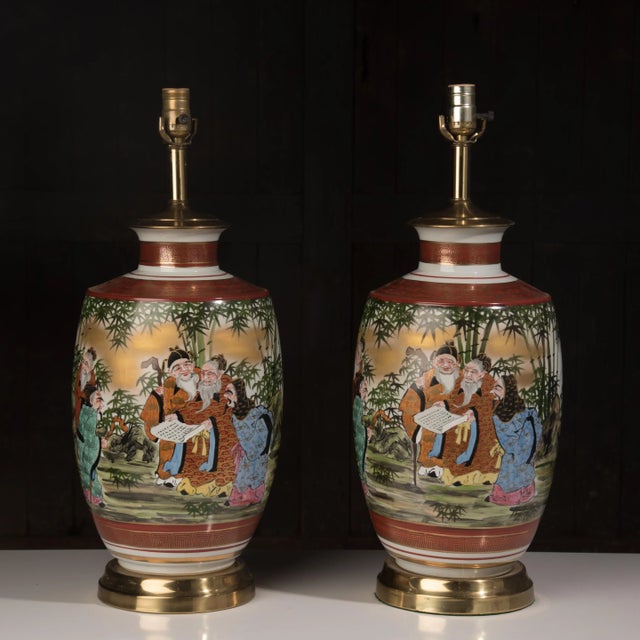 Unusually large matching hand painted porcelain table lamps on a brass bases. Both lamps are working.