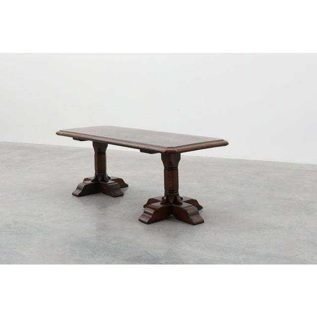 A handsome French oak dining table in the traditional refectory style, dating from the 20th century. Crafted from solid...