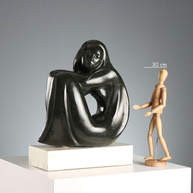 Marble sculpture depicting a stylized female nude, featuring fluid, sinuous, modernist-inspired forms that create an...