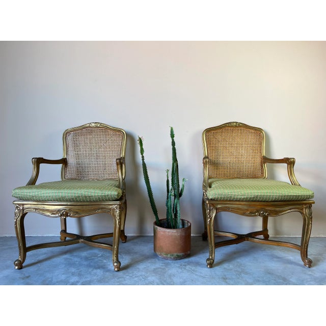 A lovely pair of Vintage Hollywood Regency Country French Louis XV style armchairs having solid carved wood frames and...