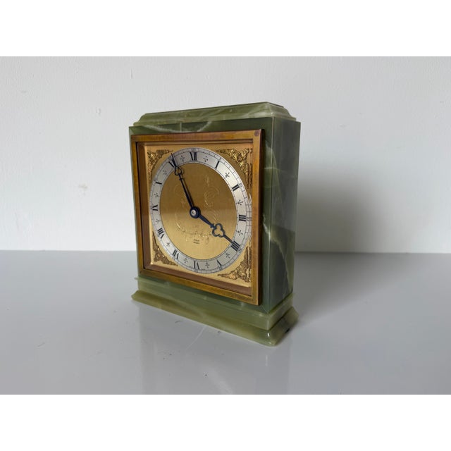 A beautifully crafted vintage mantel clock by Elliott London, featuring a solid carved green onyx case accented with a...