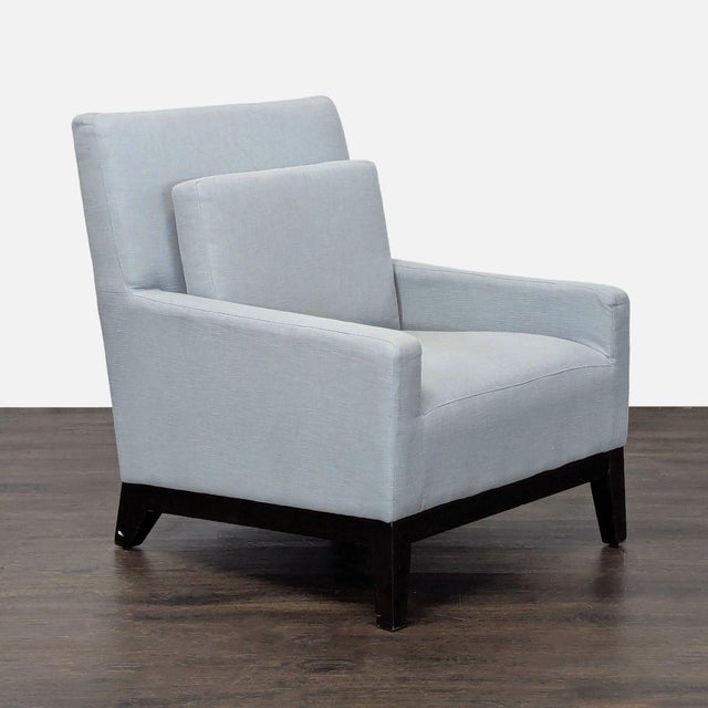 This West Elm lounge chair features a clean and modern design, upholstered in light blue fabric. The chair has comfortable...