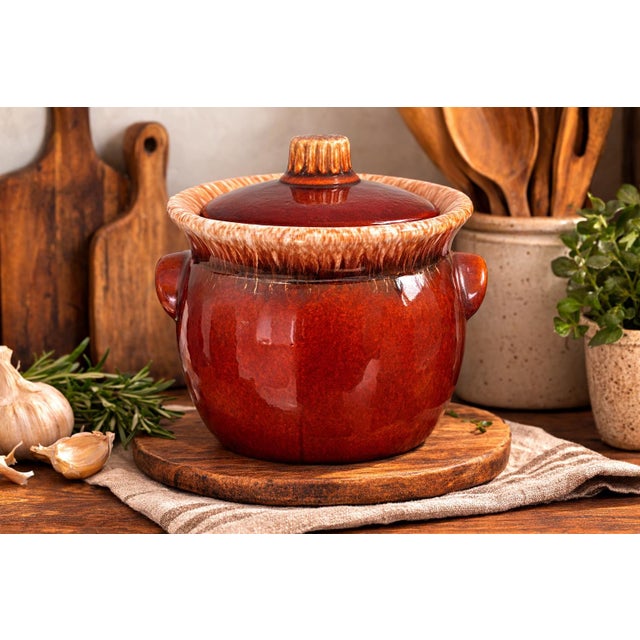 This vintage Hull Pottery oven-proof bean pot with lid showcases the warm earthy tones and functional design that made...