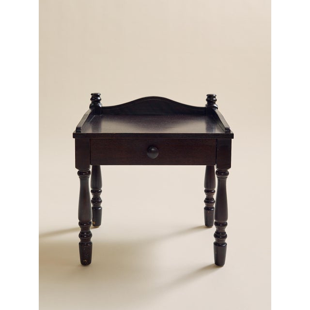 This pair of vintage Swedish nightstands features a dark painted finish, raised gallery tops, single drawers, and...