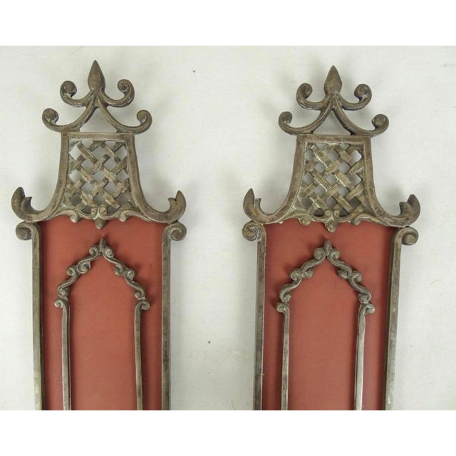 A pair of candle wall sconces with a lovely coral background The decoration is vaguely chinoiserie