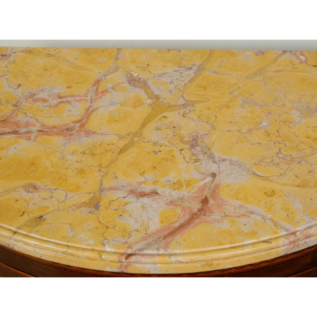 An Italian neoclassical period walnut demi-lune cabinet from the 18th century with yellow marble top. Created in Italy...