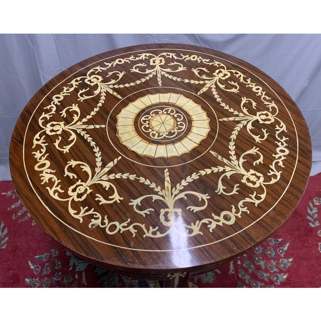 Elegant round side table with detailed hand-painted floral and ribbon motifs. Two-tier design with shaped lower shelf....