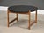 A mid century modern oak base round coffee table with a black top. Excellent condition with minor inconsistencies in...