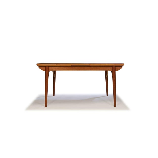Finely crafted Danish Modern dining table featuring beautifully figured old-growth teak with dramatic book-matched grain,...