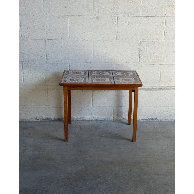Beautiful vintage Danish Modern side table crafted in teak with a decorative ceramic tile top. This Scandinavian modern...