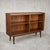 An elegant mid-century display cabinet combining walnut and teak tones with sliding glass doors. Set on tapered legs, its...
