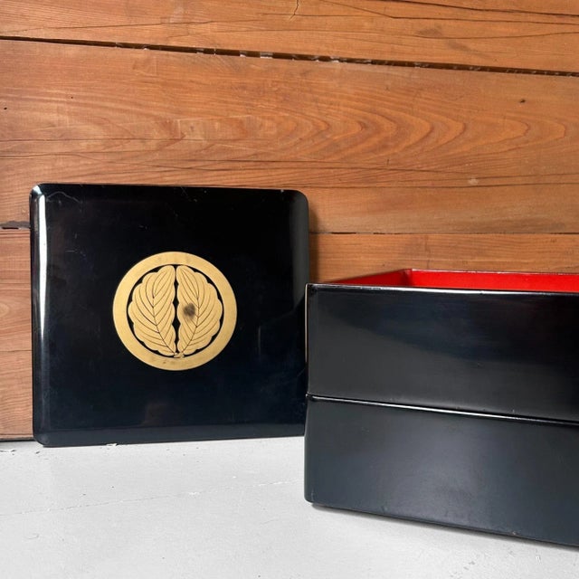 Two-tier stacking box with a black-lacquer exterior and a deep vermilion interior. Dimensions: height 16 cm, width 23 cm,...