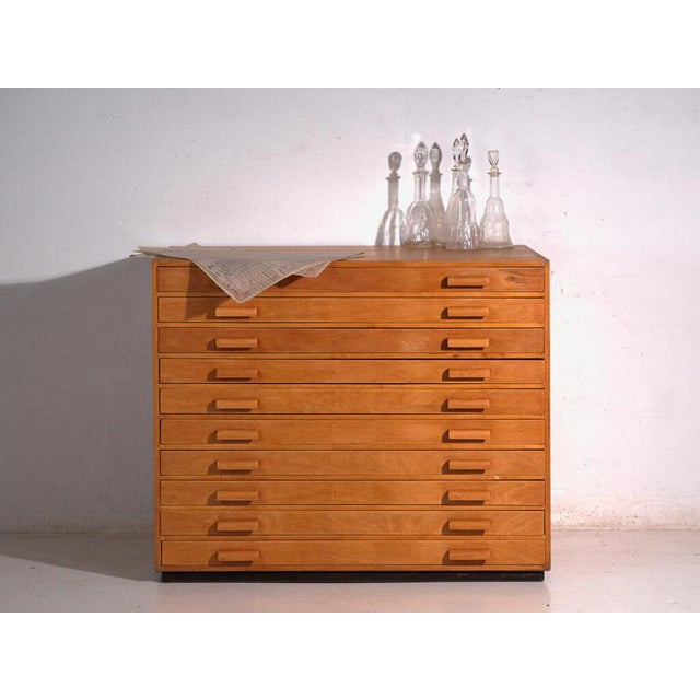 This antique plan chest in beech wood is a map chest with flat drawers and inset pulls, of cubic body and robust...