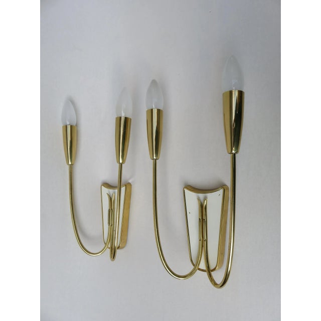 This pair of wall-mounting Italian brass lights from the 1950s are partly lacquered in white and utilize two E14 sockets...