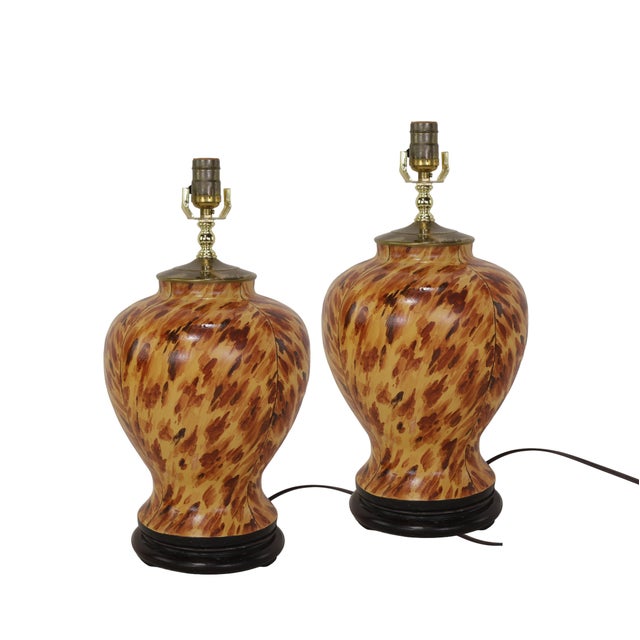 The lamps feature the iconic tortoiseshell texture, showcasing swirling patterns of dark brown, caramel, and beige. The...