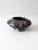 An antique three-footed bowl vase featuring an ornate cast floral design, a blue and brown painted glaze, and three...