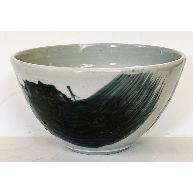 Contemporary California artist ceramic bowl hand thrown and glazed with a swash of deep grays. The hand thrown details can...