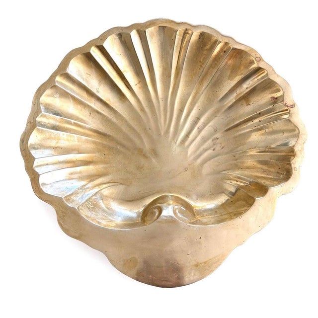 This vintage brass bowl is a 14-inch solid brass shell centerpiece with a scalloped rim and radiating fluted interior,...