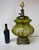 Large 1973 table lamp by E.K. with an olive-green glass body decorated with pale roses. A light inside the body shines...