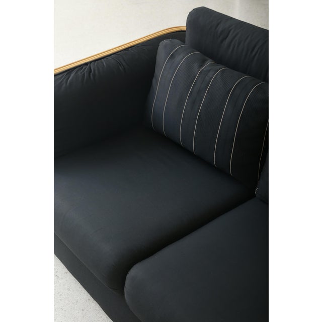 Rare vintage three seat sofa defined by its sculptural ribbed wood arms and black upholstery. Subtle pinstriped back...