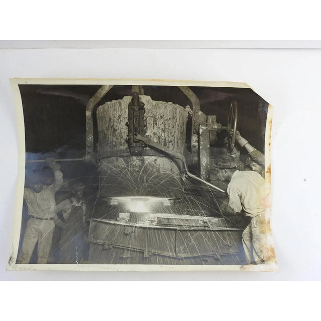 Circa 1920's photograph of steel foundry. Shows three black employees pouring molten steel into molds. Unsigned. Unframed,...