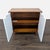 This West Elm cabinet features a wood finish with white geometric-patterned cabinet doors. It offers two spacious shelves...