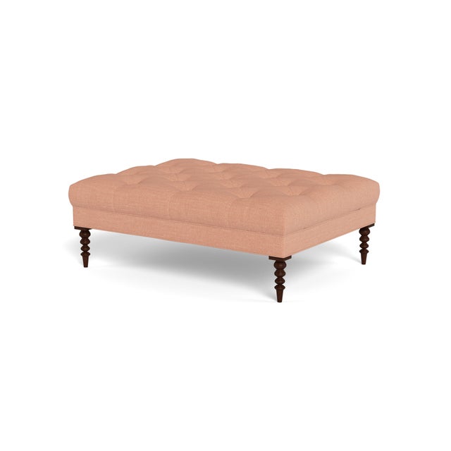 A large cocktail ottoman, with beautiful tufting set atop a trim upholstered box, with wonderfully turned legs. Legs...