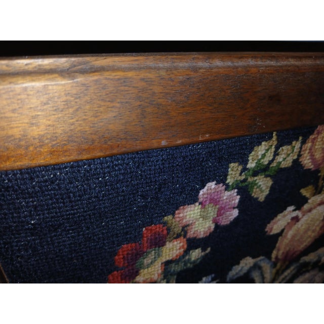 Large 1970s needlepoint hand framed wall decor. Dark blue background with floral picture. Frame is oak. Signed on back. In...