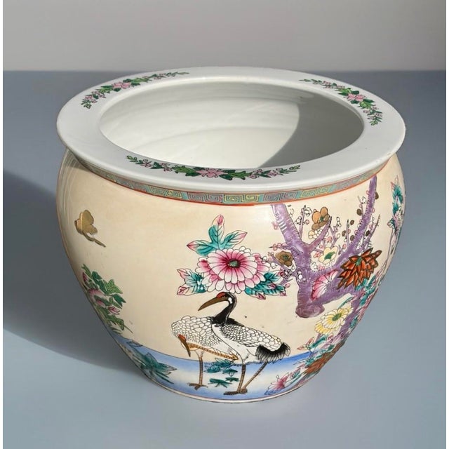 A vibrant hand‑painted fishbowl featuring colorful florals around the exterior and three lively koi swimming among aquatic...