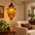 Rich amber glass and ornate metalwork give this vintage swag pendant a striking sculptural presence. Its rounded, tapering...