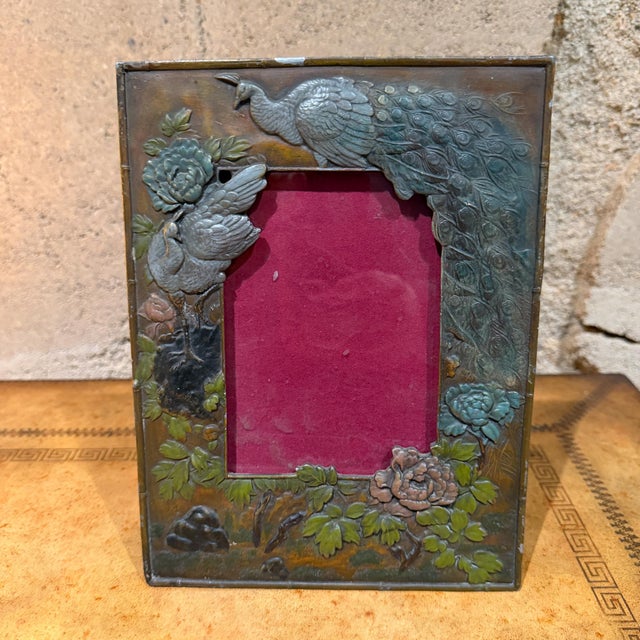 For your consideration, an antique metal picture frame featuring a high-relief design of peacocks and floral motifs. This...