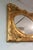 Oval mirror with ornate gold gilded and solid carved wood frame.