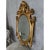 Italian rococo hand carved giltwood mirror featuring ornate filigree and gilding, scrolls, leaves, crests, and columns. No...