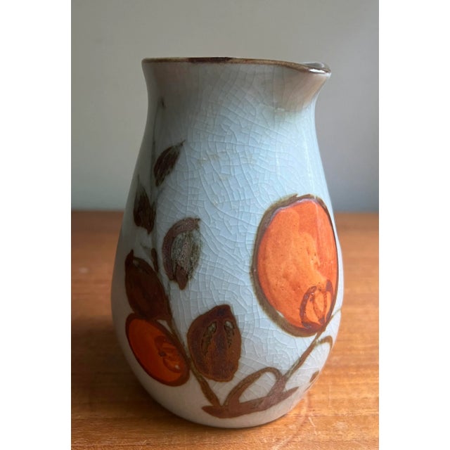 This quaint mediterranean style vessel can double as a small vase, or a catch all for pens and pencils etc. Sleek handle....