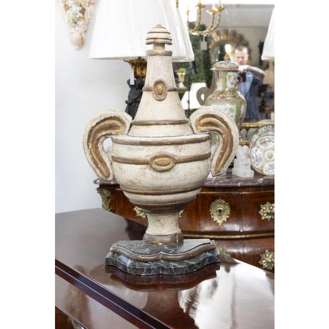 This is an elegant pair of Neoclassical urn-form architectural elements, sculpted to project gracefully from the wall...