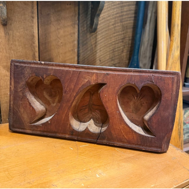 Beautiful antique Quebec wooden sugar mold featuring three deeply carved heart-shaped cavities, each decorated with...