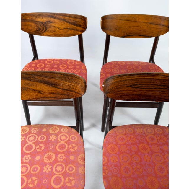 Set of four dining room chairs in rosewood and upholstered with red fabric, of Danish design from the 1960s. The chairs...