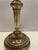 Antique brass baluster-form candlestick, engraved with naturalistic forms on the candle cup, with a scrolling design on...