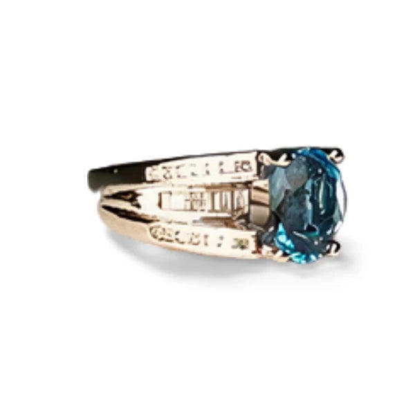 Stunning 14K White Gold Ring featuring a 9x7 mm natural blue topaz surrounded by 28 brilliant round diamonds and 14...