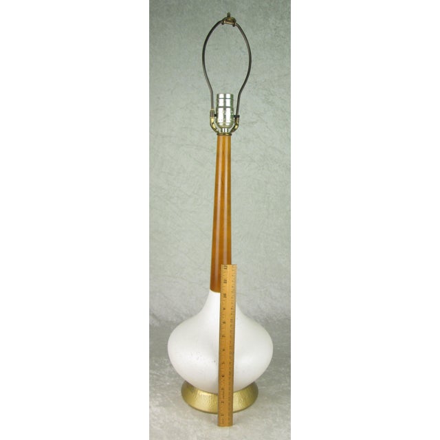 Vintage mid century modern pottery and wood genie bottle table lamp. The lamp is white pottery with a wood neck that...