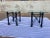 Vintage pair of Giacometti style twisted wrought iron faux verdigris patinated painted base beveled glass top side tables.