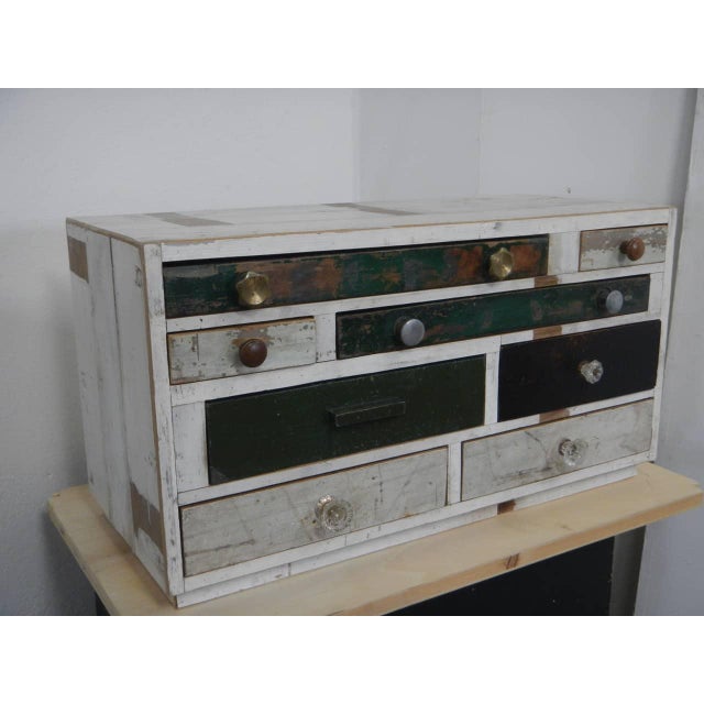 Made of fir wood and lined with reclaimed wood. It features 8 drawers of various sizes. Original iron and brass handles....