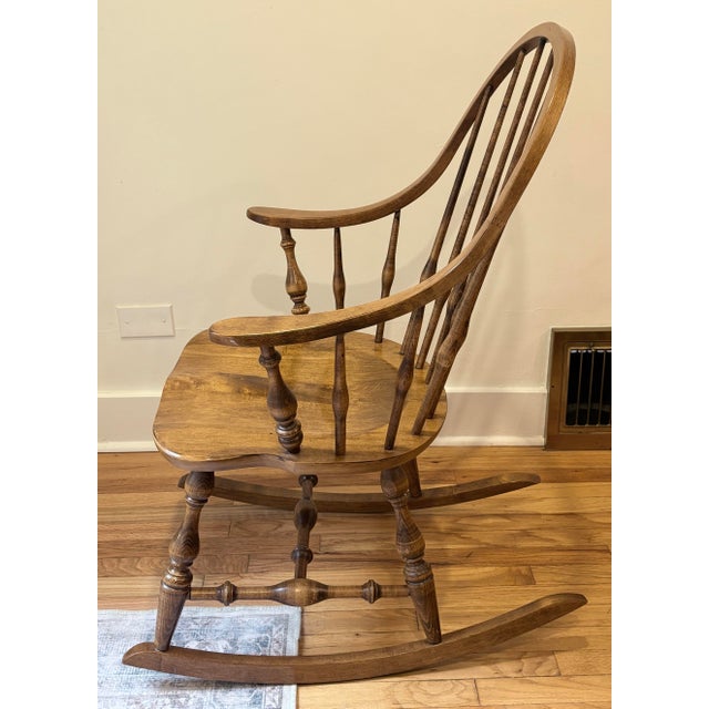Ethan Allen Windsor-style Bowback Rocking Chair Features a curved top rail, turned spindles, and sculpted sculpted seat....