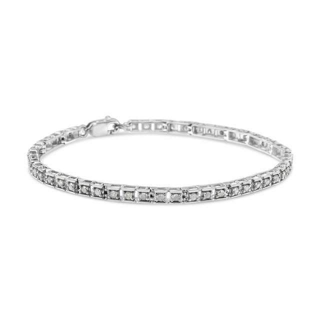 Elegant and timeless, this sterling silver tennis bracelet features 1.0 carat total weight of round, brilliant cut...