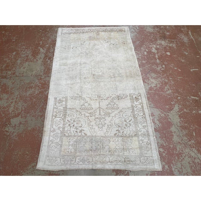 Vintage Turkish rug, hand-knotted in Turkey from 100% wool. Measuring 4’1” x 7’3”, the rug features a subtle and softly...