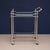This features a refined open-frame design with slender, bamboo-inspired supports, polished metal rails, and elegant finial...