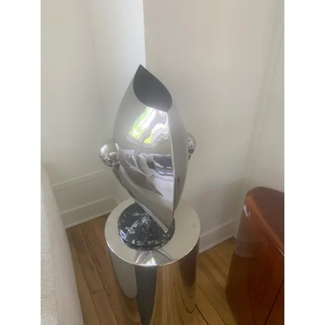 This is the Marquise Vase by Brueton. The vase is of polished stainless steel with a negro marquina stone.