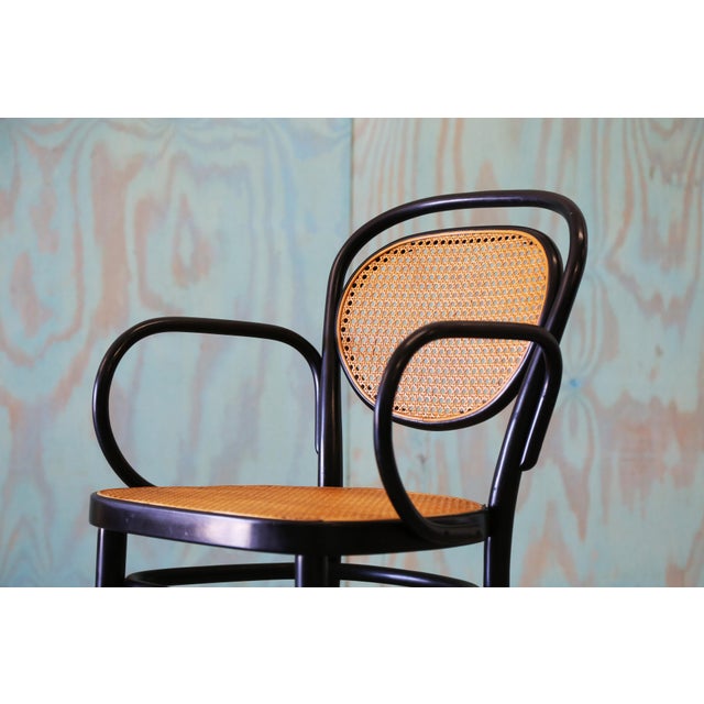 The classic No. 215 RF Thonet chair with black lacquered bentwood frame, cane seat and cane back. Elegant form, c. 1980s....