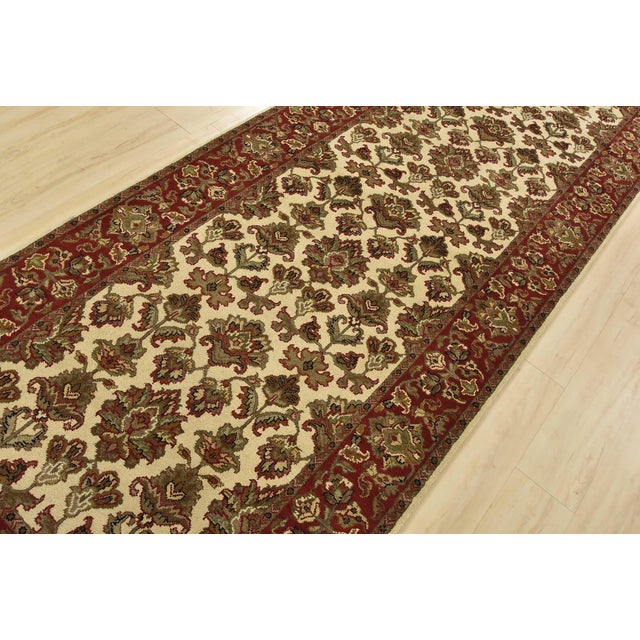 An authentic Agra runner hand-knotted with fine wool on a cotton foundation. This rug features a botanical design set...